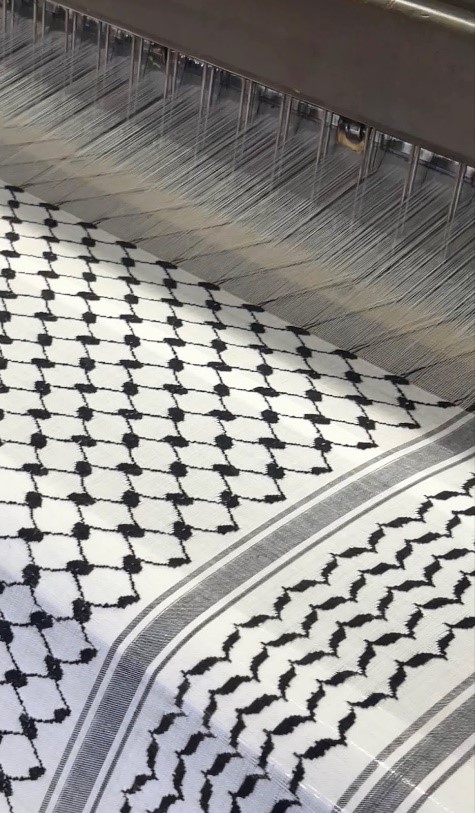 Caption: Cotton thread is intricately weaved by fifteen complex industrial looms to create the notable keffiyeh pattern. The black and white color scheme is the original iteration of the scarf, and makes up seventy percent of the factory’s sales. 
